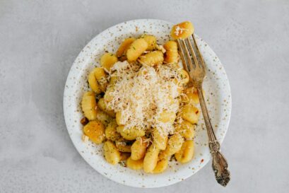 A Gnocchi on a Ceramic Plate with Fork on the Side